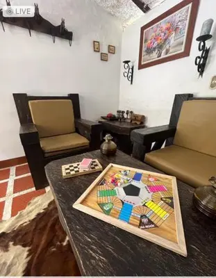 a living room with a table and two chairs at Villa Arte Rustico in Ciudad Bolívar