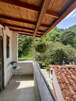 a balcony of a house with a chair on it at Villa Arte Rustico in Ciudad Bolívar