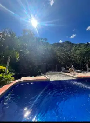 a large blue swimming pool with the sun in the sky at Villa Arte Rustico in Ciudad Bolívar