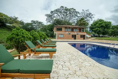 a row of lounge chairs next to a swimming pool at Tres Lagos Hotel in San Jerónimo