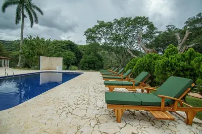 a row of lounge chairs next to a swimming pool at Tres Lagos Hotel in San Jerónimo