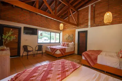 a bedroom with two beds and a table and chairs at Tres Lagos Hotel in San Jerónimo