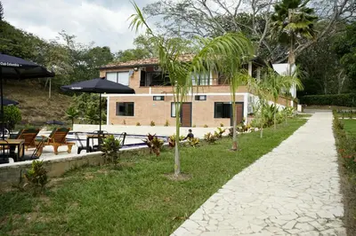 a house with a courtyard with tables and umbrellas at Tres Lagos Hotel in San Jerónimo