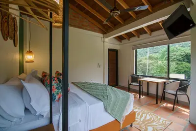 a bedroom with a bed and a table with a television at Tres Lagos Hotel in San Jerónimo