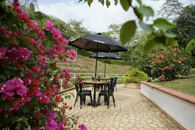 a table and chairs with umbrellas in a garden at Tres Lagos Hotel in San Jerónimo