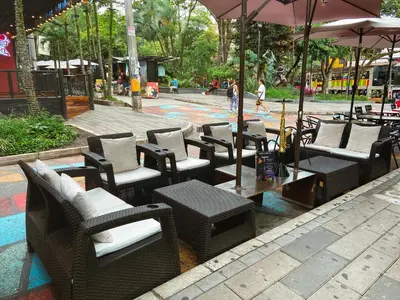 a group of chairs and tables and an umbrella at Hotel Lleras # 1 in Medellín
