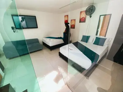 a room with two beds and a glass wall at Hotel Lleras # 1 in Medellín