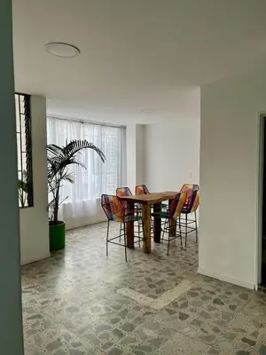 a dining room with a wooden table and chairs at Entre Jardines in Medellín
