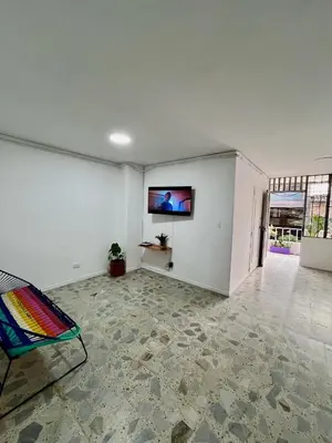 an empty living room with a flat screen tv on the wall at Entre Jardines in Medellín