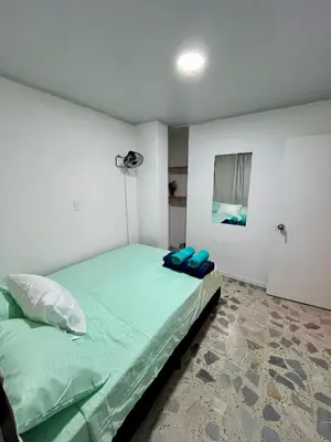 a small bedroom with a green bed in it at Entre Jardines in Medellín