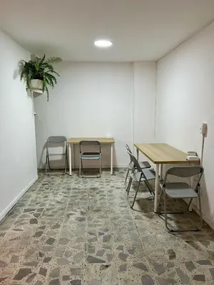 a meeting room with two tables and chairs and a plant at Entre Jardines in Medellín