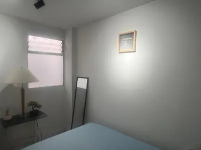 a white room with a bed and a lamp and a window at Habitación 1 Belen san Bernando in Medellín