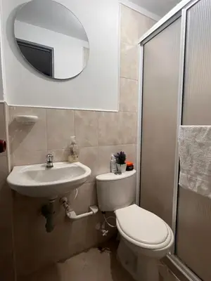 a bathroom with a toilet and a sink and a mirror at Habitación 1 Belen san Bernando in Medellín