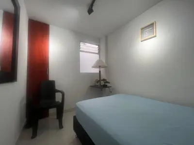 a bedroom with a bed and a chair and a window at Habitación 1 Belen san Bernando in Medellín