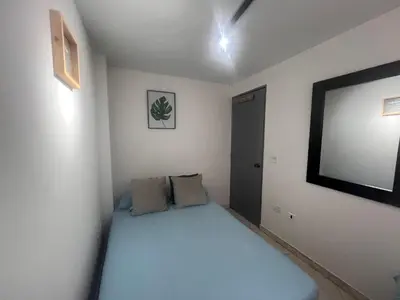 a small bedroom with a bed and a flat screen tv at Habitación 1 Belen san Bernando in Medellín