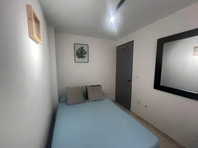 a bedroom with a bed and a flat screen tv at Habitación 1 Belen san Bernando in Medellín