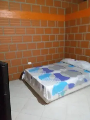 a bed in a room with a brick wall at Rancho forest Victoria in Victoria