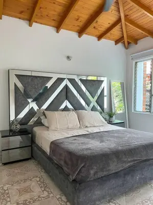 a bedroom with a large bed and a wooden ceiling at Party house, rooftop terrace with Jacuzzi poblado, Movie Theater in Envigado