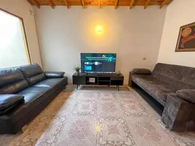 a living room with a couch and a flat screen tv at Party house, rooftop terrace with Jacuzzi poblado, Movie Theater in Envigado