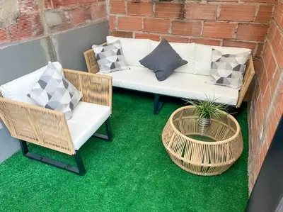 a patio with two wicker chairs and a coffee table at Party house, rooftop terrace with Jacuzzi poblado, Movie Theater in Envigado