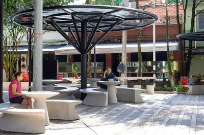 two women sitting at tables in front of a building at Party house, rooftop terrace with Jacuzzi poblado, Movie Theater in Envigado