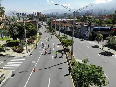 a group of people riding bikes down a city street at Party house, rooftop terrace with Jacuzzi poblado, Movie Theater in Envigado