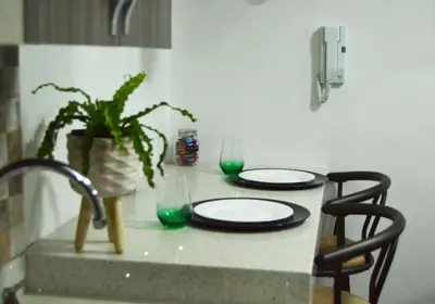 a table with two plates and a plant on it at Cómo en casa in Itagüí