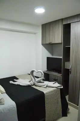 a hotel room with a bed with towels on it at Cómo en casa in Itagüí