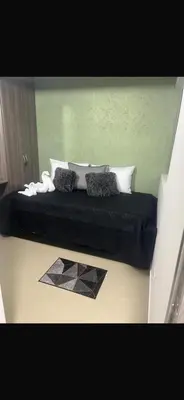 a bedroom with a black bed with pillows on it at Cómo en casa in Itagüí