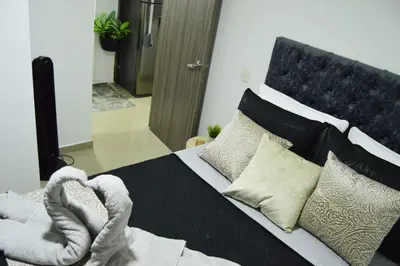 a bedroom with a black and white bed with pillows at Cómo en casa in Itagüí