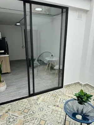 a room with a sliding glass door with a table at Dream apt close to Unicentro - spacious - with AC in Medellín