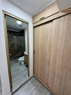 a bathroom with a toilet and a wooden door at Dream apt close to Unicentro - spacious - with AC in Medellín