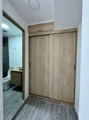 a bathroom with a wooden sliding door in a room at Dream apt close to Unicentro - spacious - with AC in Medellín