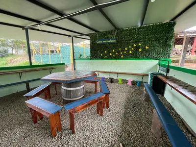 a picnic table and benches in a playground at Camping tipo eco-confort Refugio Lancaster in Urrao