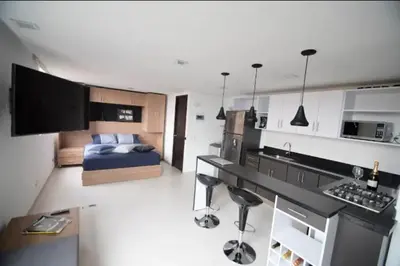 a kitchen and living room with a bed in a room at Espacio Ideal En Pausa in Medellín