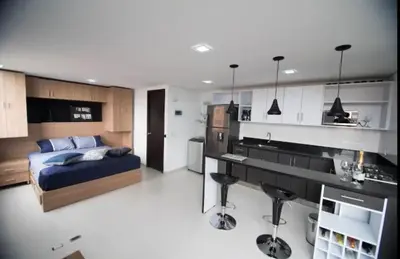 a bedroom with a bed and a kitchen in it at Espacio Ideal En Pausa in Medellín