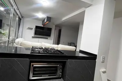 a kitchen with a black counter top with a stove at Mirador la casa del cóndor 3 habitaciones in Itagüí