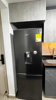 a black refrigerator in a kitchen with a sink at Mirador la casa del cóndor 3 habitaciones in Itagüí