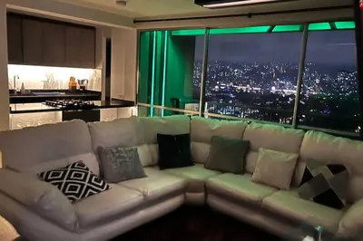 a white couch in a living room with a large window at Mirador la casa del cóndor 3 habitaciones in Itagüí