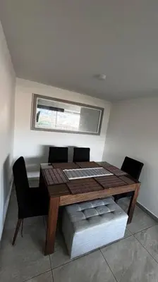 a dining room table with two chairs and a window at Mirador la casa del cóndor 3 habitaciones in Itagüí