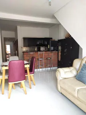 a living room with a couch and a table with chairs at Hospedaje Casa Silvana in Jardin