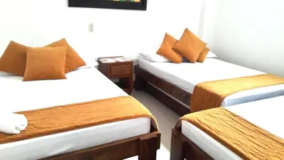 a room with two beds with brown and white at Hospedaje Casa Silvana in Jardin