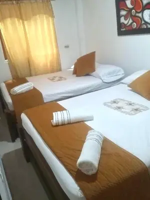 two beds in a hotel room with towels on them at Hospedaje Casa Silvana in Jardin