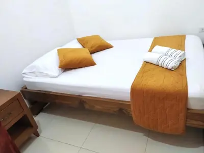 a bed with two pillows on it in a room at Hospedaje Casa Silvana in Jardin
