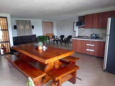 a living room with a wooden table and a kitchen at Polandia in Villa Silvia