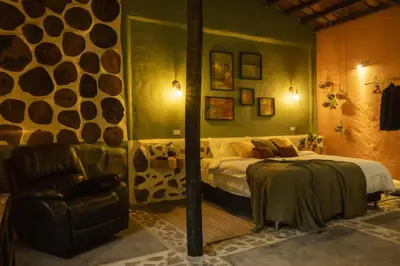 a bedroom with a bed and a chair at Peaceful rustic cabin steps from town in Jericó