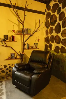 a leather reclining chair in a room with a stone wall at Peaceful rustic cabin steps from town in Jericó