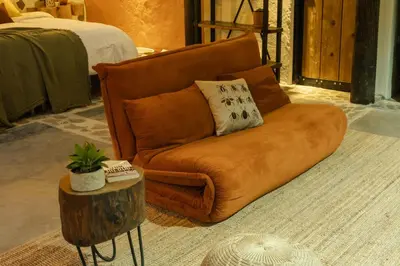 a brown couch sitting in a living room with a table at Peaceful rustic cabin steps from town in Jericó