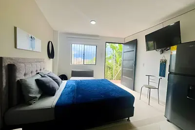 a bedroom with a bed with a blue comforter at 9804 · 9804 Loft Env. good view local experience confort in Envigado