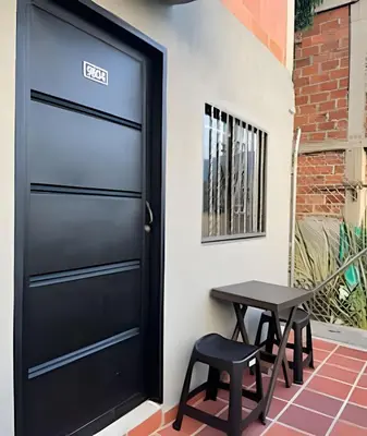 a black door with two stools next to a table at 9804 · 9804 Loft Env. good view local experience confort in Envigado